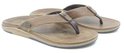 Twee bruine leren Reef teenslippers met Reef logo op de band.