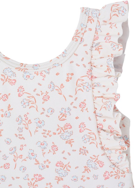 Detail van het witte badpak met volantjes aan de schouderbanden en bloemenprint.