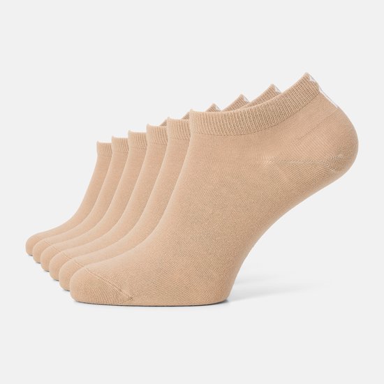 Rij van zes beige enkelsokken, met een witte 'W' aan de achterkant van de rechter sok.
