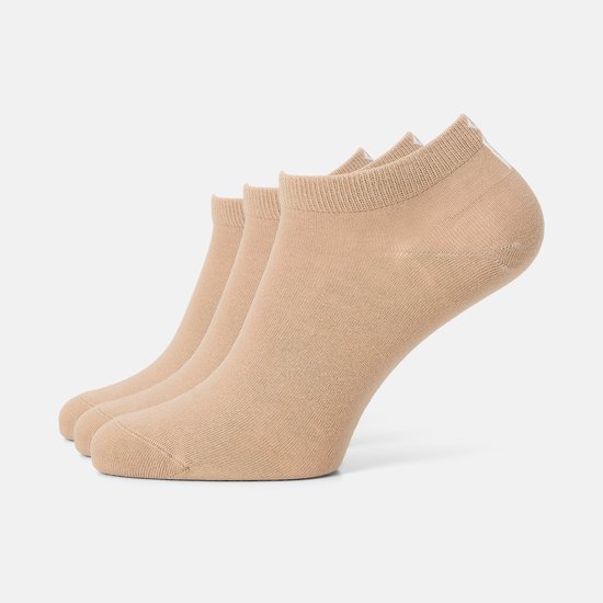 Drie beige enkelsokken op een rij, met een zachte textuur.
