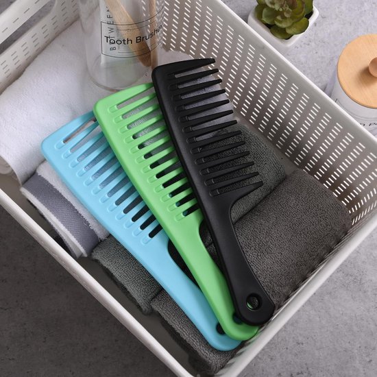 Drie kammen met extra brede tanden in blauw, zwart en groen, in een witte mand met handdoeken.