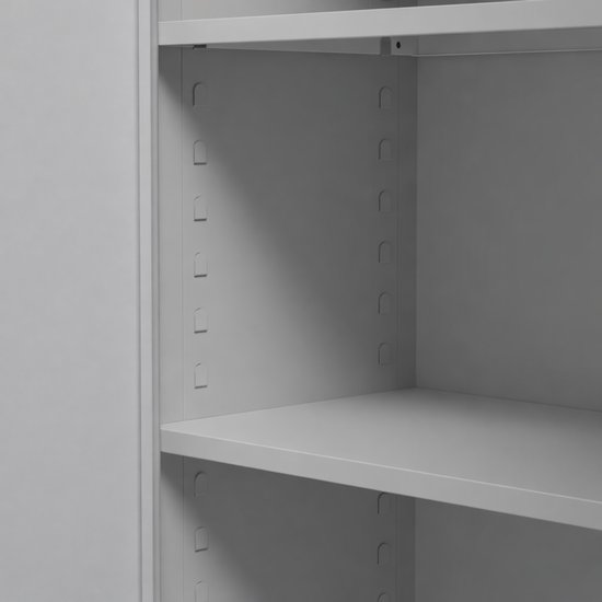 Detail van de grijze metalen archiefkast, zicht op de planken en bevestigingsgaten.