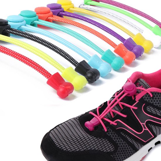 Close-up van een grijze sneaker met roze elastische veters, strakgetrokken met roze stopper en clip. Op de achtergrond diverse gekleurde elastische veters.