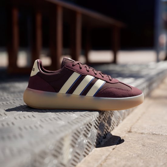 Bordeauxrode sneaker met beige en blauwe strepen, beige zool.