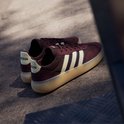 Bordeauxrode sneaker met beige en blauwe strepen, beige zool.