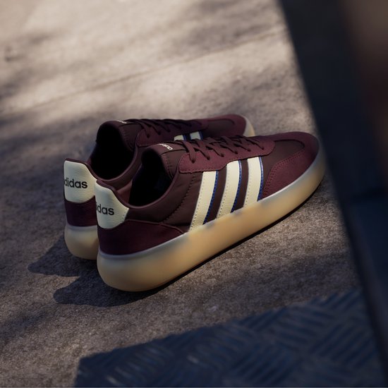 Bordeauxrode sneaker met beige en blauwe strepen, beige zool.