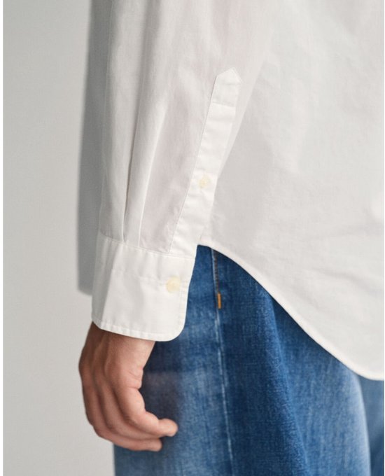 Detail van een wit overhemd: mouw met knoopsluiting.