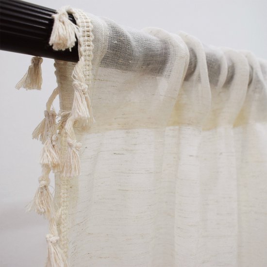 Crème vitrage met decoratieve beige kwastjes aan de bovenrand.