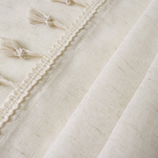 Crème vitrage met decoratieve kwastjes en rijgdetaillering.