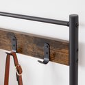 Bruine houten plank met zwart metalen kledinghaken en een tas eraan.