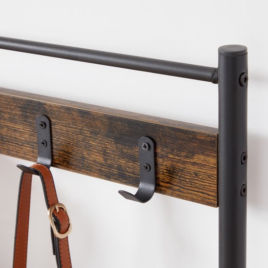 Bruine houten plank met zwart metalen kledinghaken en een tas eraan.