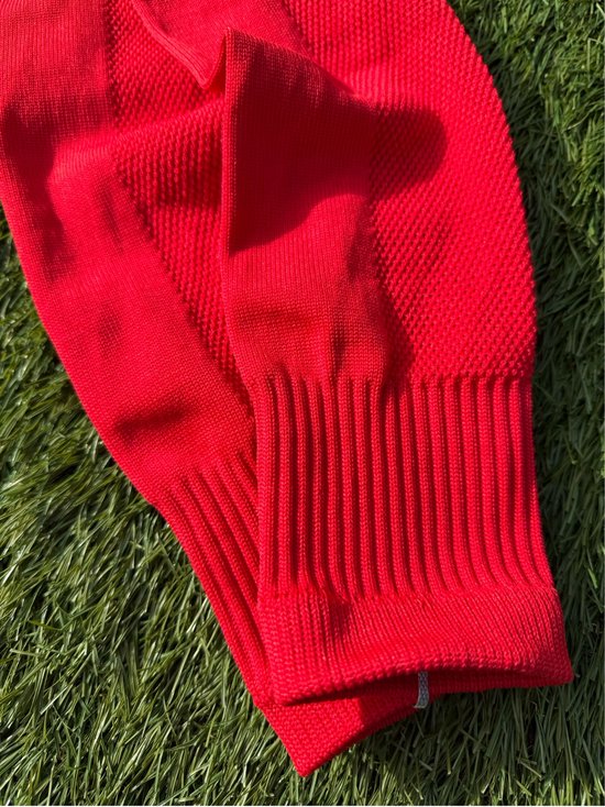 Heldere rode voetbalsleeves met ribbelboord aan de onderkant.