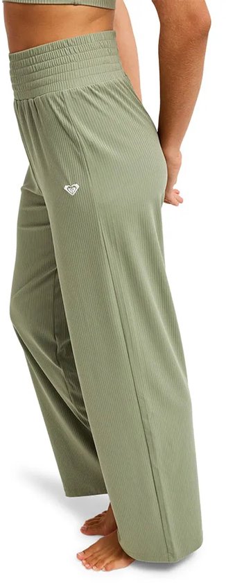 Lichtgroene, geribbelde broek met wijde pijpen en elastische tailleband, zij-aanzicht.
