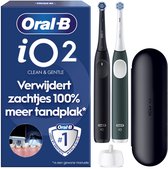 Oral-B iO2 Duo Edition elektrische tandenborstels in nachtzwart en bosgroen, inclusief reishoes en oplader.