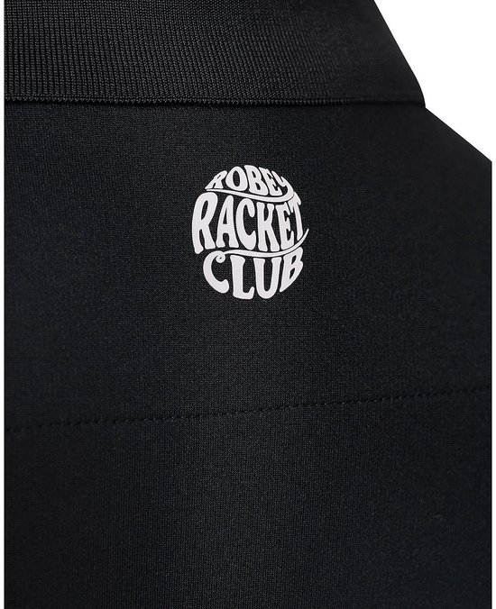 Close-up van de kraag van een zwarte poloshirt met het witte 'Racket Club' logo.