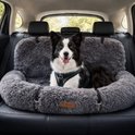 Bordercollie in een donkergrijs, pluizig autostoeltje met halsband en riempje.