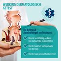 Main tenant un modèle anatomique de l'anus et pointant vers le modèle avec un stylo, avec le texte 'Efficacité testée dermatologiquement'.