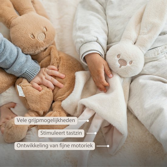 Twee baby's vasthouden een crèmekleurig en bruin konijnen knuffeldoekje. Stimuleert tastzin en fijne motoriek.