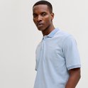 Man in lichtblauw poloshirt met witte kraag en manchetten.