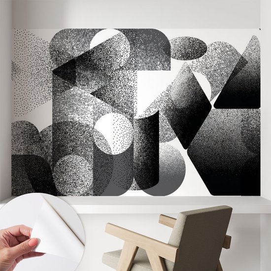 Zwart-wit geometrische vormen fotobehang op een muur, met een gedeeltelijke weergave van de zelfklevende achterkant.