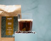 Glas espresso met schuim, naast een zak Georgie's 'Single Origin Colombia' koffie en koffiebonen.
