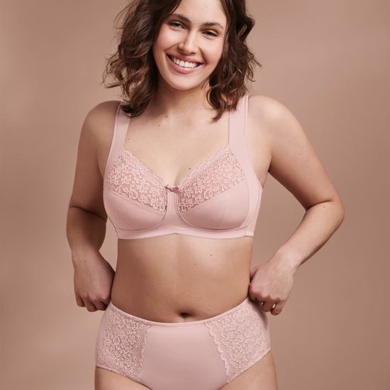 Vrolijke vrouw met een roze beha en bijpassend broekje met kant.