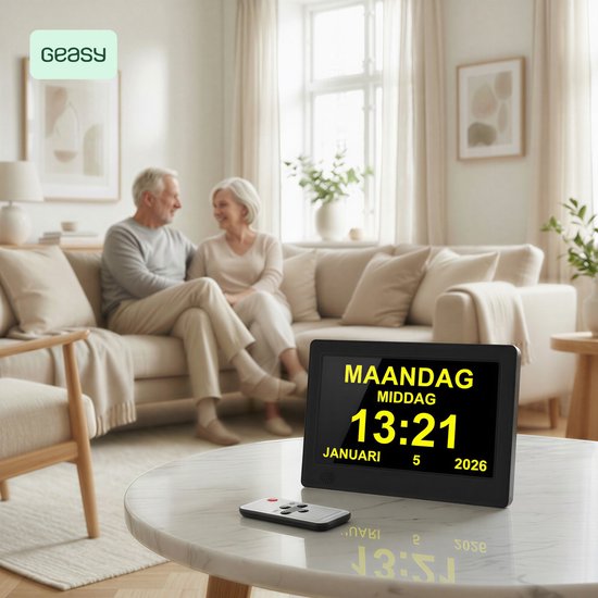 Digitale kalenderklok met gele tekst op zwart display, op marmeren tafel voor seniorenkoppel op sofa.