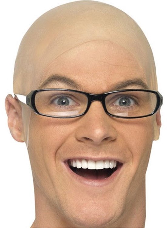 Un homme chauve avec une perruque et des lunettes noires, souriant.
