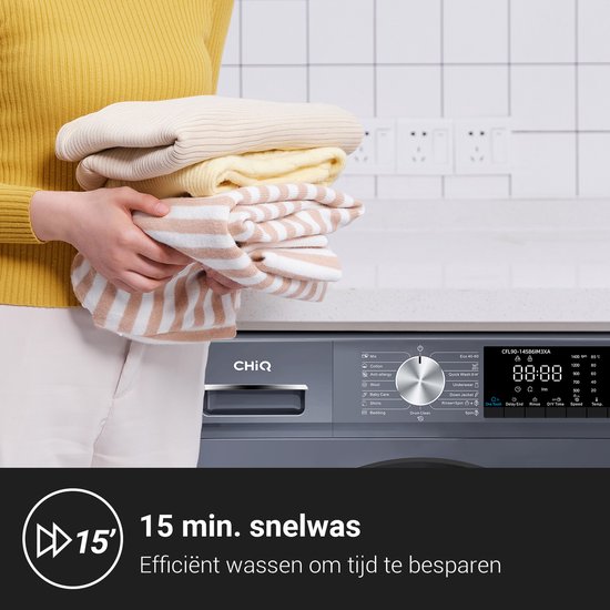 Une femme tenant une pile de linge repassé, à côté d'un lave-linge gris foncé avec le symbole de lavage rapide de 15 minutes.