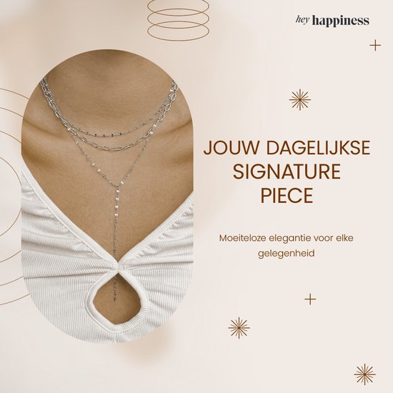 Gelaagde zilverkleurige ketting met fijne schakels en een Y-vormige drop, gedragen door een model.