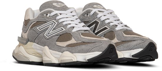 Voorkant van grijze New Balance U9060 sneakers met beige panelen en witte veters.