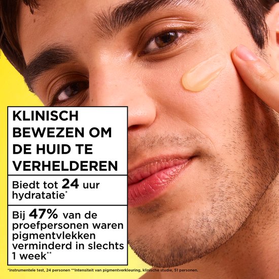 Een man met een lichte huid waarop een oranje crème is aangebracht, met de tekst 'Klinisch bewezen om de huid te verhelderen'.