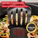 Een spatel met eten, aardappelen, paddestoelen en asperges, wordt uit een pan getild. FUSIONCORE staat in een gouden cirkel.