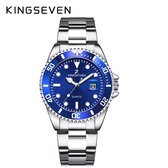 Zilverkleurig horloge met blauwe wijzerplaat, datumweergave, gestreepte lunette en zilverkleurige metalen band.