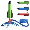 Groene, blauwe en rode raketten met zwarte vinnen op lanceerplatform met pomp.
