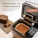 Broodbakmachine met noten- en rozijnendispenser, toont brood en deksel met notenmix.