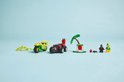 Gele en rode LEGO-voertuigen met minifiguren, een palmboom en spinnenwebben.