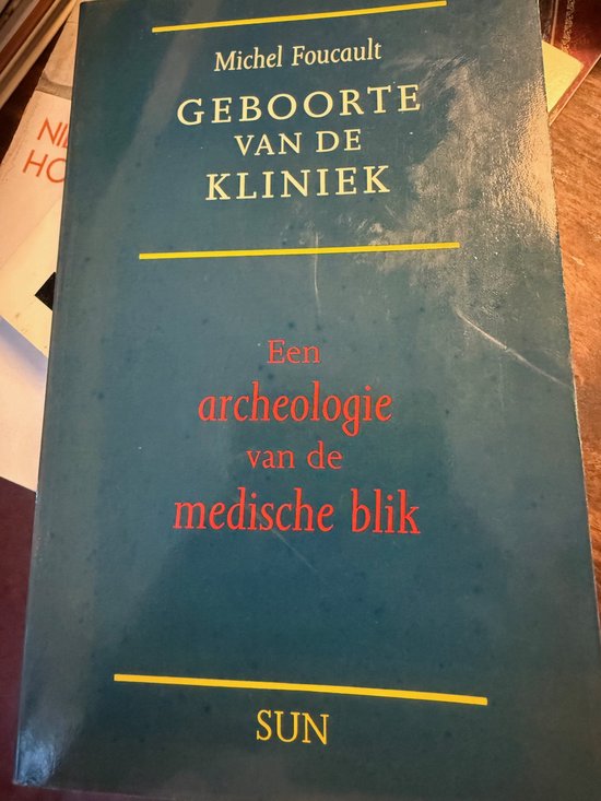 Boekomslag van 'Geboorte van de kliniek' door Michel Foucault, met tekst in het geel en rood op een blauwgroene achtergrond.