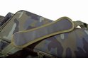 Schouderpad van donkergrijs leer op een camouflage tas, met groene hengsels.