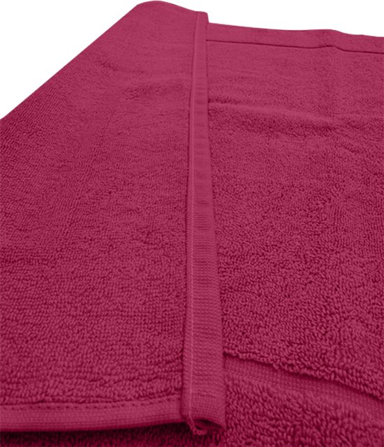Gedetailleerde hoek van de fuchsia badmat die de zachte textuur toont.