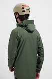 Man met helm, draagt een olijfgroene regenjas.