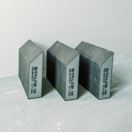 Drie grijze schuursponzen met schuine zijden. Labels met 'STALCO PERFECT S-71284' en '100'.