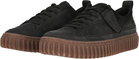 Paar zwarte sneakers met bruine plateauzolen.