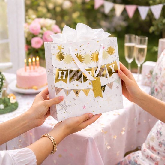 Sac cadeau blanc avec des étoiles dorées et une bannière 'Happy Birthday', présenté sur une table de fête.