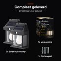 2 zwarte solar buitenlampen met glazen kap en zichtbare LED-lamp, met verpakking en ophangset.