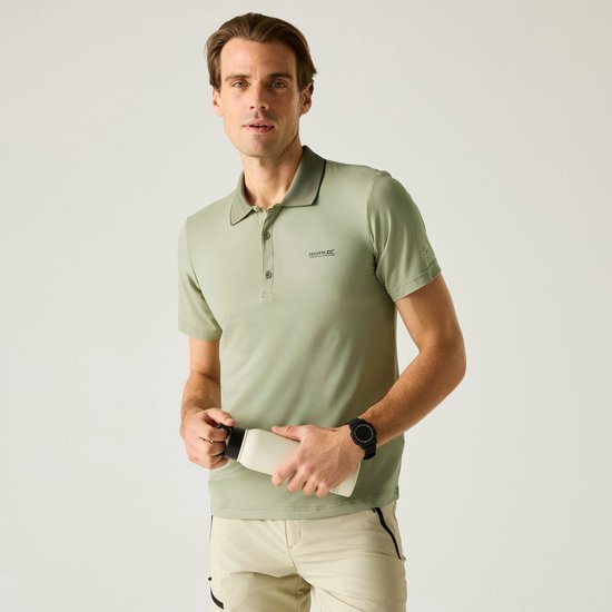 Een man in een lichtgroen poloshirt en beige shorts, die een witte fles vasthoudt.
