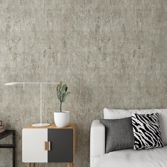 Salon avec un mur en béton gris, un canapé blanc avec des coussins et une table d'appoint avec une lampe.