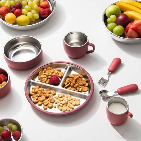 Roze serviesset met een verdeeld bord, kom, beker en bestek, gevuld met snacks en fruit.