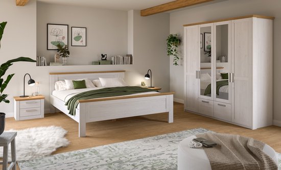 Witte slaapkamer met gestyled bed, nachtkastjes, kledingkast met spiegels en groene accenten.
