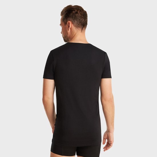 Man met een zwarte t-shirt met v-hals, achterkant zichtbaar.